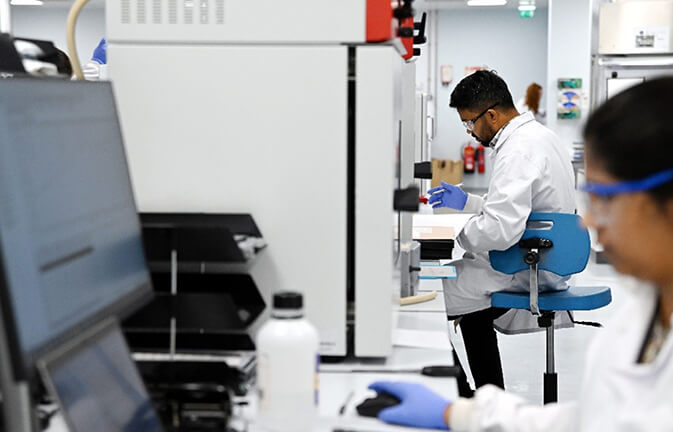 Promover o desenvolvimento de medicamentos para os doentes: Colegas a colaborar num laboratório de investigação e desenvolvimento.